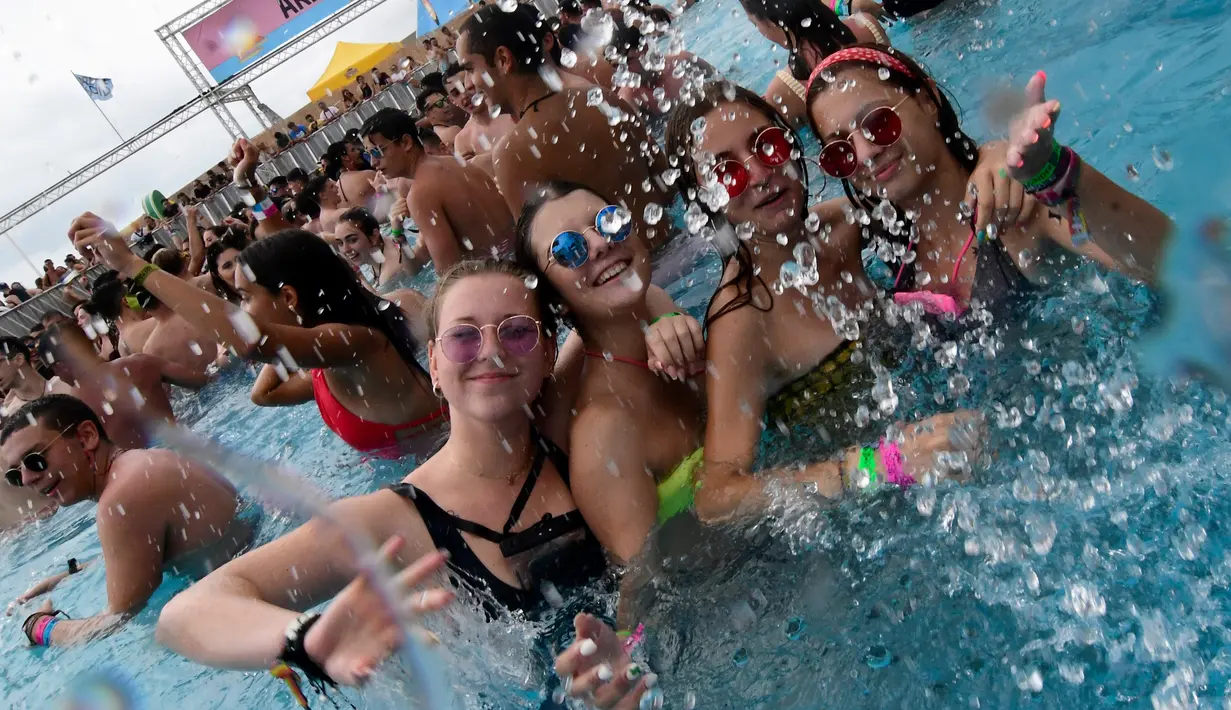 Sejumlah wanita bersuka ria mencipratkan air di kolam renang selama Arenal Sound Music Festival 2019 di Burriana, Spanyol (31/7/2019). Festival musik ini berlangsung dari 30 Juli sampai 4 Agustus 2019.  (AFP Photo/Jose Jordan)