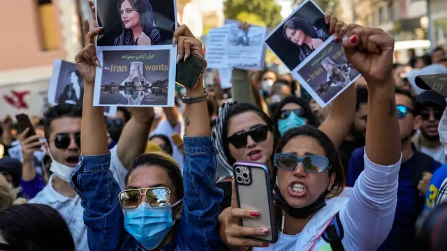 Wanita memegang foto Mahsa Amini dari Iran saat mereka meneriakkan slogan-slogan selama protes terhadap kematiannya, di luar konsulat jenderal Iran di Istanbul, Turki, 21 September 2022. (AP)