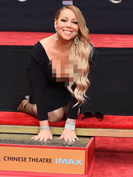 Penyanyi Mariah Carey membuat cetakan tangannya di semen di TCL Chinese Theatre di Los Angeles, AS (1/11). Penyanyi 47 tahun ini mendapat penghargaan membuat cetakan tangan dan kaki di TCL Chinese Theatre. (Photo by Jordan Strauss/Invision/AP)