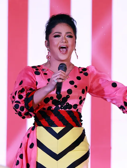 Sesuai dengan tema unik yang mengarah pada sirkus, Krisdayanti pun mengenakan kostum panggung dengan unsur sirkus pula. Istri dari Raul Lemos ini memakai kostum berwarna kontras antara paduan warna pink serta kuning. (Deki Prayoga/Bintang.com)