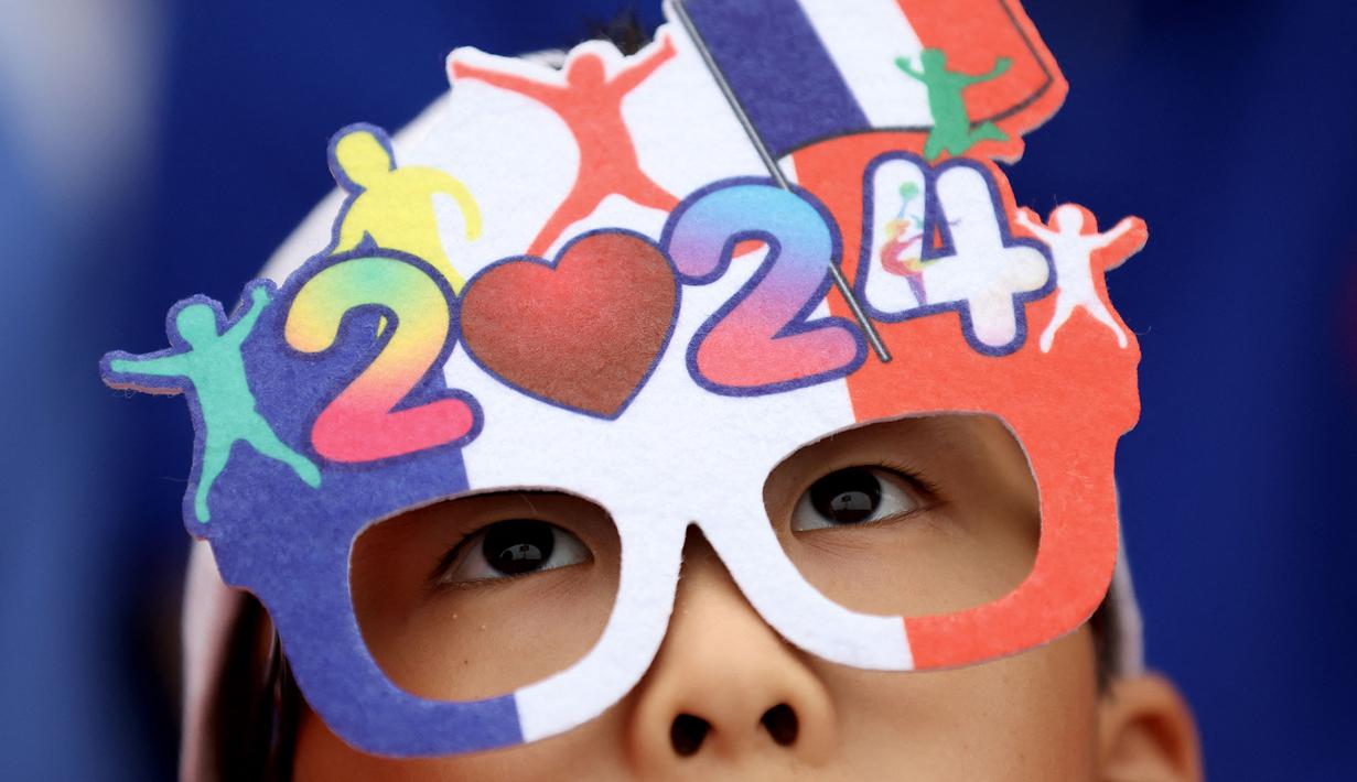 Seorang penonton terlihat mengenakan kacamata berwarna bendera nasional Prancis selama upacara pembukaan Olimpiade Paris 2024 pada 26 Juli 2024. (AFP/Pool/Steph Chambers)