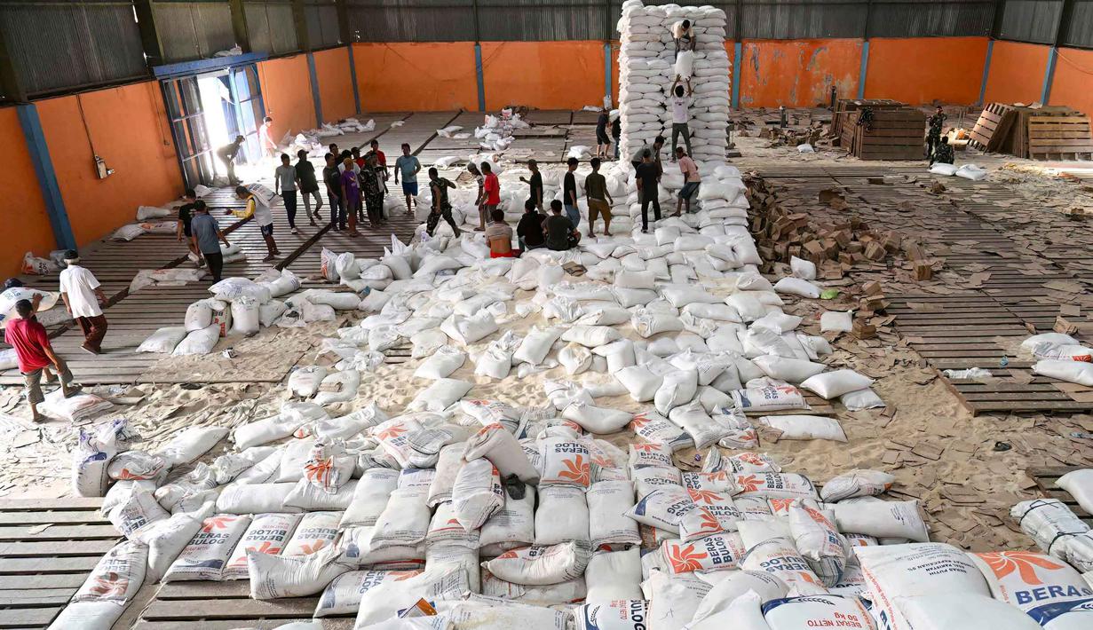 Sebelumnya, pada akhir bulan lalu, terjadi penjarahan gudang Bulog yang berada di Kecamatan Sarudik, Kota Sibolga. Tampak dalam foto, warga desa menerima bahan pangan pokok yang didistribusikan di tengah upaya bantuan dari gudang beras pemerintah di Sarudik, Tapanuli Tengah, Provinsi Sumatra Utara, pada Rabu 3 Desember 2025. (YT Hariono/AFP)