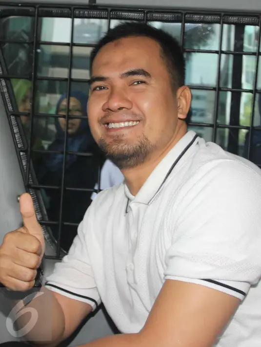 Saipul Jamil mengacungkan jempol saat berada di dalam mobil tahanan KPK, Jakarta, Kamis (22/12). Saipul Jamil usai diperiksa sebagai tersangka kasus dugaan suap penanganan perkara di Pengadilan Negeri Jakarta Utara. (Liputan6.com/Helmi Afandi)