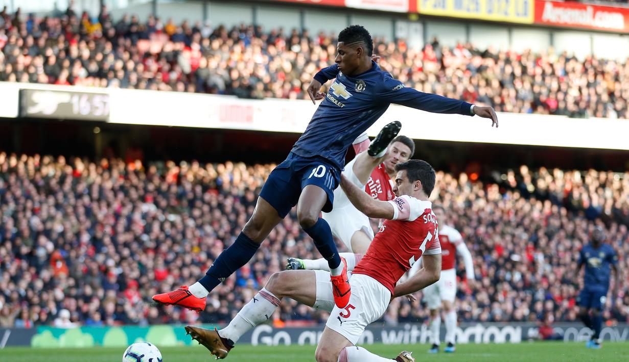 Marcus Rashford dihentikan Sokratis Papasthatopoulus pada laga lanjutan Premier League yang berlangsung di Stadion Emirates, London, Minggu (10/3). Arsenal menang 2-0 atas Man United. (AFP/Ben Stansall)