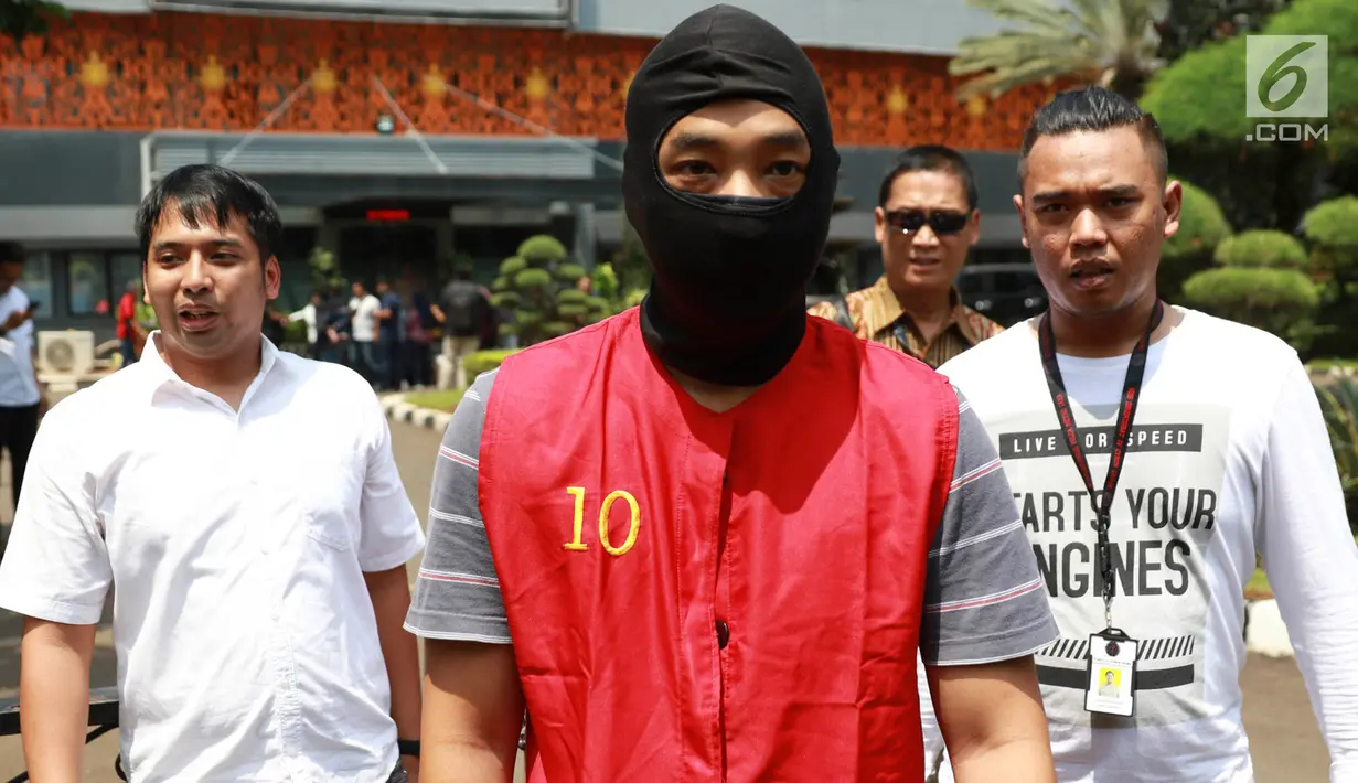 Tersangka Ramyadjie Priambodo dikawal polisi saat akan dilimpahkan ke kejaksaan di Polda Metro Jaya, Jakarta, Kamis (25/4). Pelimpahan tahap dua dilakukan usai kejaksaan menetapkan berkas perkara Ramyadjie lengkap (P-21) secara materiil dan formil pada 18 April 2019. (Liputan6.com/Immanuel Antonius)