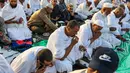 Umat muslim menyantap kurma saat mengakhiri puasa di hari pertama bulan suci Ramadhan, sambil duduk di Masjidil Haram di kota suci Mekkah pada 23 Maret 2023. (AFP/Abdel Ghani BASHIR/AFP)