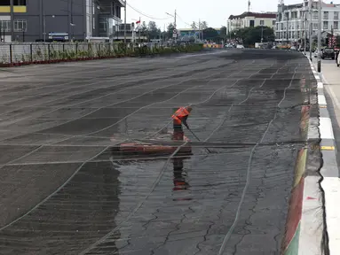 Petugas PPSU membersihkan sampah yang tertutup jaring hitam di Kali Item, Kemayoran, Jakarta, Jumat (20/7). Pemasangan jaring dilakukan untuk menutupi keruhnya air dan bau tak sedap di Kali Item. (Liputan6.com/Arya Manggala)