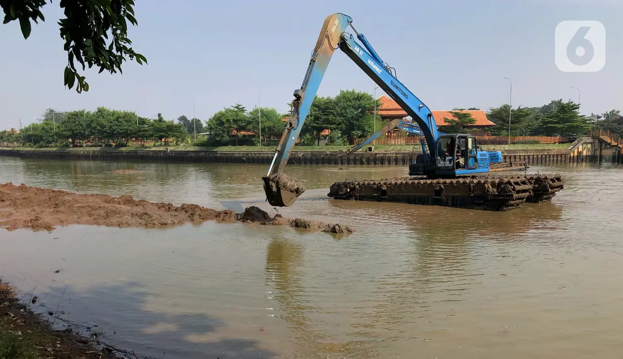 Petugas menggunakan alat berat untuk mengeruk lumpur di Setu Babakan, Jakarta, Selasa (30/6/2020). Pengerukan dilakukan guna mengembalikan kedalaman setu sehingga menambah daya tampungnya. (Liputan6.com/Immanuel Antonius)