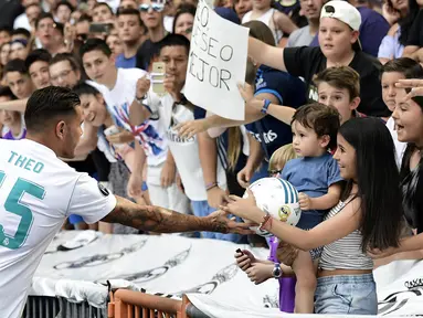 Pemain baru Real Madrid, Theo Hernandez, menyapa suporter saat baru diperkenalkan di Stadion Santiago Bernabeu, Madrid, Senin (10/7/2017). (AFP/Javier Soriano)