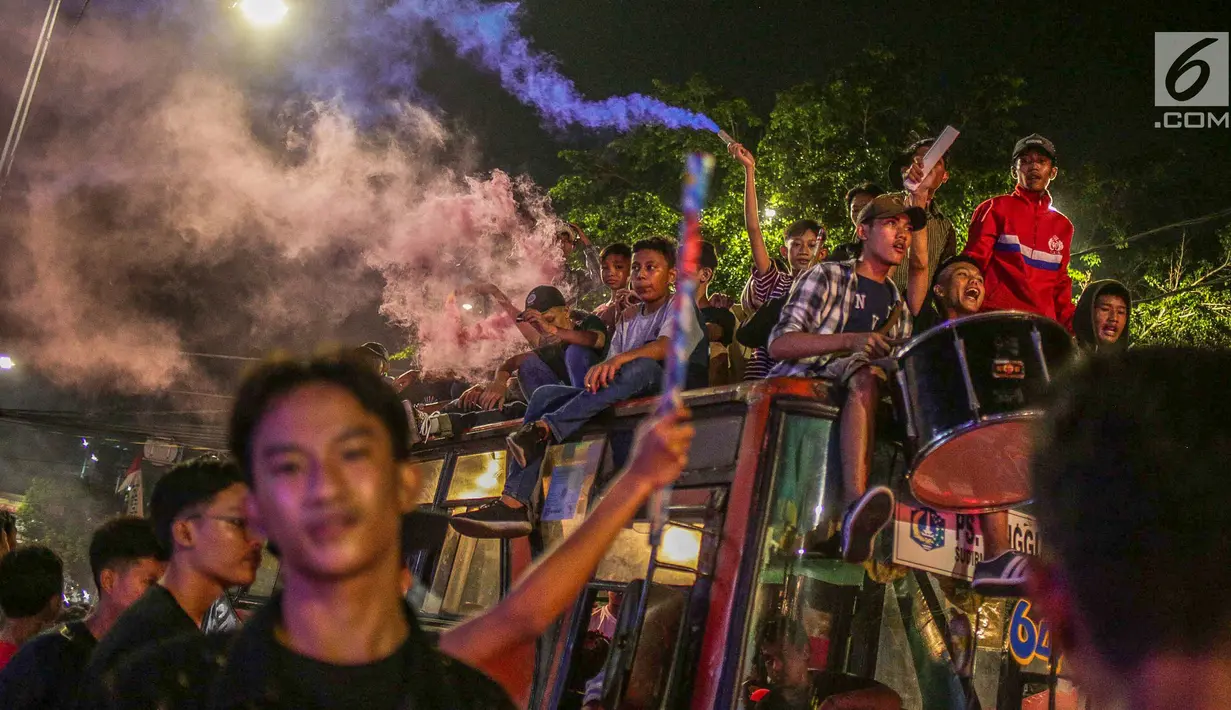 Warga konvoi menggunakan bus saat merayakan malam takbiran menyambut Hari Raya Idul Fitri 2019 di kawasan Tanah Abang, Jakarta, Selasa (4/6/2019). Pemerintah menetapkan Hari Raya Idul Fitri 1440 Hijriah jatuh pada hari Rabu 5 Juni 2019. (Liputan6.com/Faizal Fanani)