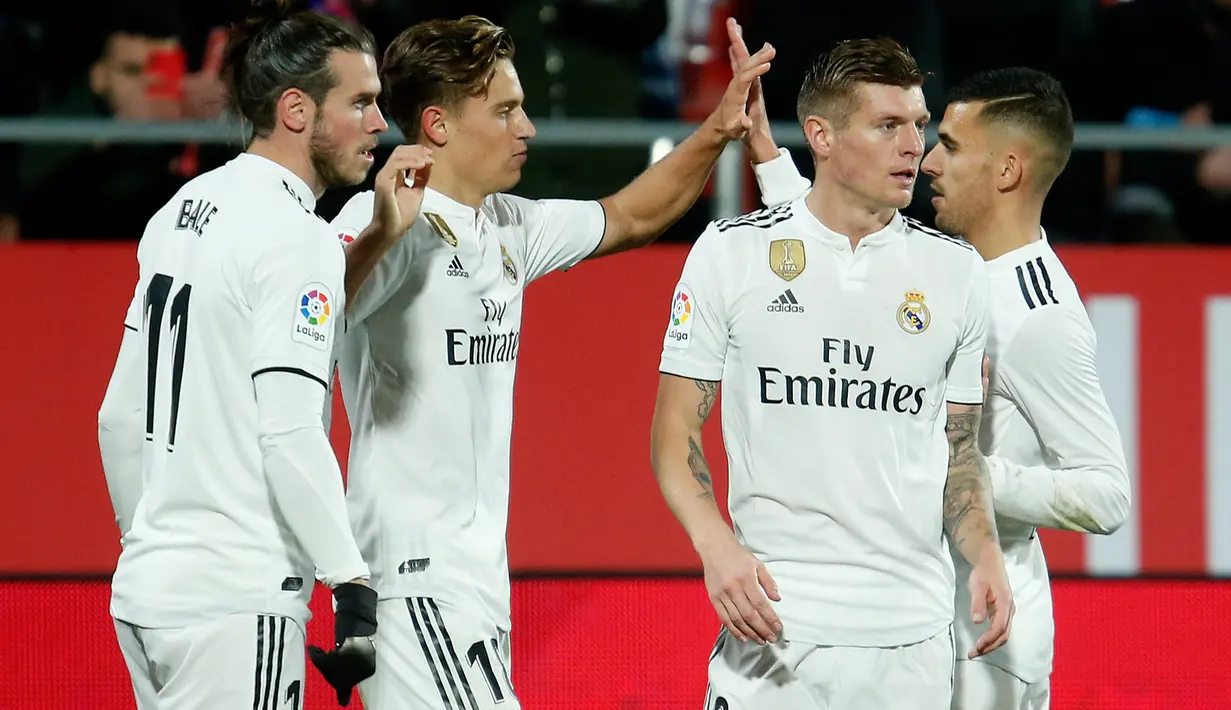 Gelandang Real Madrid, Marcos Llorente berselebrasi dnegan rekannya setelah mencetak gol ke gawang Girona pada leg kedua perempat final Copa del Rey di Stadion Municipal de Montilivi, Kamis (31/1). Real Madrid berhasil menang 3-1. (PAU BARRENA/AFP)