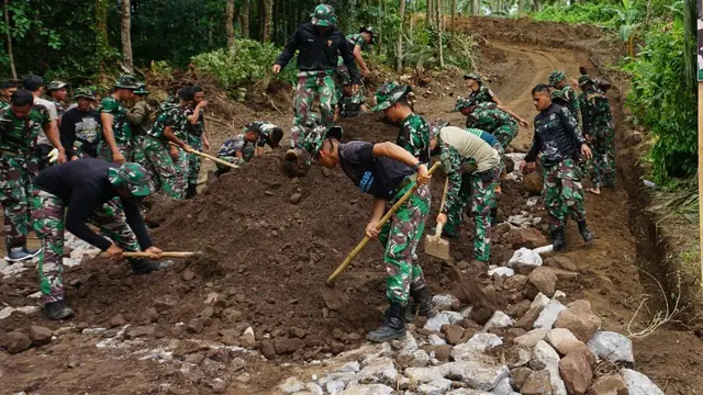 Kerjasama antara Satgas TMMD ke-117 Kodim 1309/Manado bersama warga Kampung Lahendong merintis akses jalan yang memadai. (Foto: Yoseph Ikanubun/Liputan6.com)