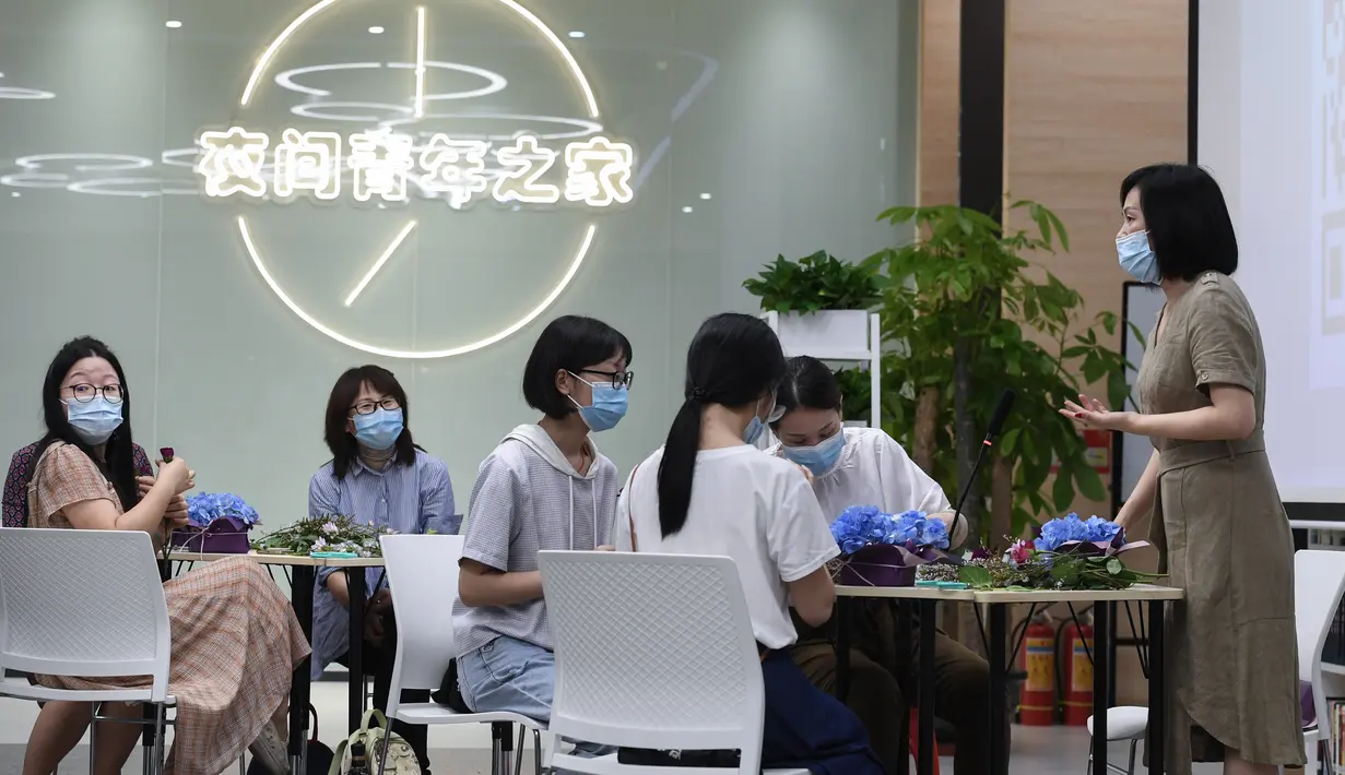 Orang-orang menghadiri kelas merangkai bunga di "Youth Channel" di Shenzhen, China (2/9/2020). Youth Channel adalah pusat komunitas yang menyediakan kuliah dan kelas budaya, seperti kursus ukulele dan keterampilan merangkai bunga bagi kaum muda sepulang bekerja. (Xinhua/Mao Siqian)