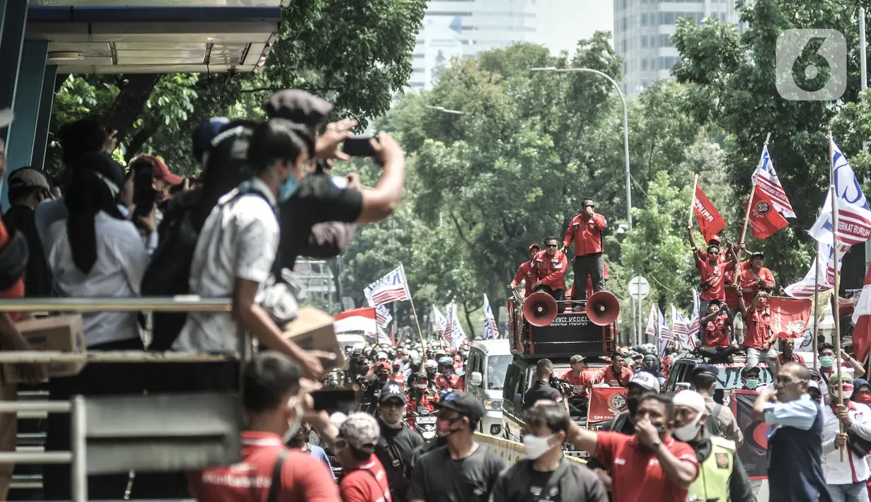 Warga memfoto aksi konvoi massa dari Konfederasi Serikat Buruh Seluruh Indonesia (KSBSI) di Jalan Medan Merdeka Barat, Jakarta, Senin (12/10/2020). Ratusan massa buruh ini hendak berunjuk rasa menolak pengesahan omnibus law Undang-Undang Cipta Kerja di Istana Negara. (merdeka.com/Iqbal S Nugroho)