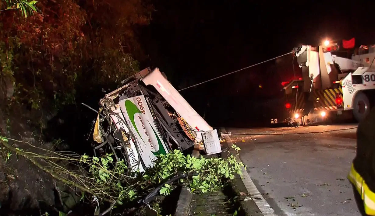 Alat derek menarik sebuah bus yang terjun bebas ke jurang di negara bagian Sao Paulo, Brasil, Kamis (9/6). Sopir dari bus yang membawa 46 penumpang kehilangan kendali dan menabrak sebuah batu di jalur berlawanan. (RECORD TV/AFP)