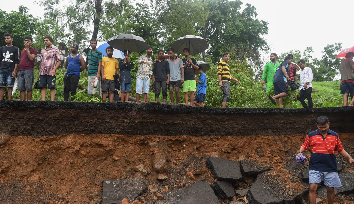 Sejumlah warga berada di lokasi runtuhnya tembok di Mumbai, India (2/7/2019). Sedikitnya 15 orang tewas dan 69 orang lainya luka ketika sebuah tembok runtuh saat hujan lebat monsun. (AFP Photo/Punit Paranjpe)