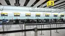 Penutupan ini imbas serangan yang diluncurkan Amerika Serikat dan Israel terhadap Iran pada Sabtu (28/2/2026) pagi. Tampak dalam foto, meja-meja kosong terlihat di konter check-in maskapai penerbangan Etihad di Bandara Heathrow, London pada Minggu 1 Maret 2026. (JUSTIN TALLIS/AFP)