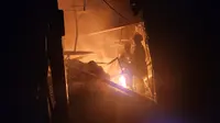 Petugas DPKP Kota Depok berusaha memadamkan api yang membakar toko bangunan di Jalan H Sulaiman, Bedahan, Sawangan, Depok. Kebakaran terjadi pada Selasa (19/3/2024) petang. (Liputan6.com/Dicky Agung Prihanto)