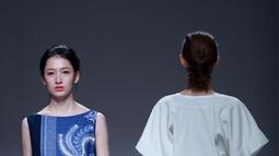 Model berjalan diatas catwalk mengenakan busana rancangan desainer Xuefei Sun yang mirip motif batik dalam China Fashion Week di Beijing, Tiongkok (30/10). Unsur oriental Batik Lasem Cina ini biasanya berupa motif fauna Cina. (AFP/STR)