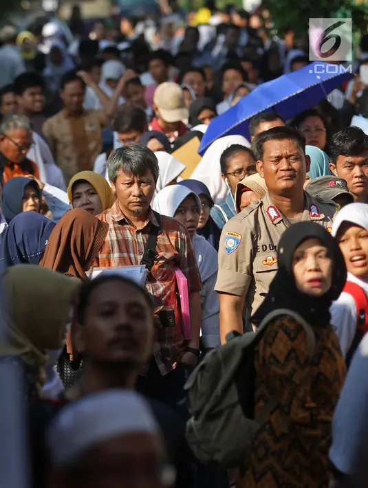 Antrean siswa dengan orangtua murid saat akan mengikuti seleksi Penerimaan Peserta Didik Baru (PPDB) di SMAN 1 Depok, Kota Depok, Jawa Barat, Selasa (18/6/2019). PPDB SMA dibagi menjadi tiga jalur yakni zonasi, prestasi, dan pemindahan orangtua. (Liputan6.com/Herman Zakharia)
