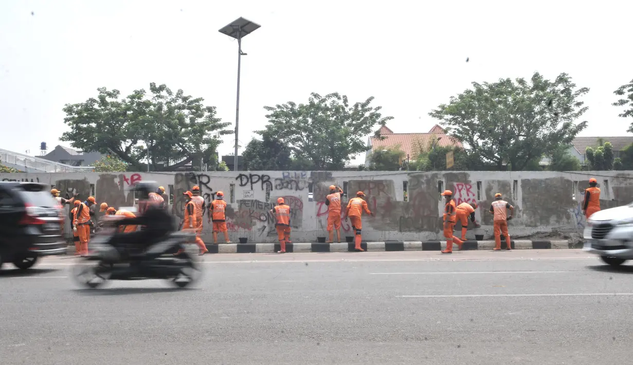 Petugas PPSU membersihkan coretan yang mengotori tembok di kawasan Gedung DPR, Jakarta, Rabu (25/9/2019). Demonstrasi mahasiswa yang berujung ricuh yang berujung kerusuhan tersebut menyebabkan fasilitas umum rusak dan penuh coretan yang dibuat oleh pendemo. (merdeka.com/Iqbal S Nugroho)