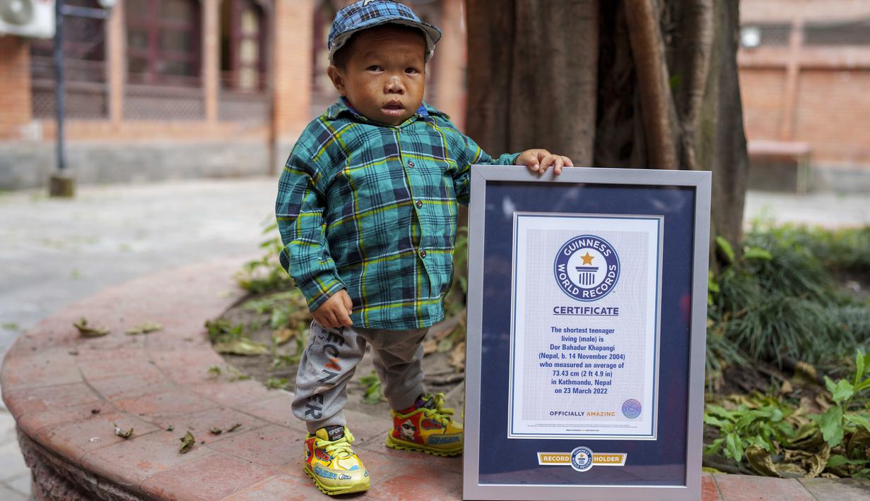 Dor Bahadur Khapangi memegang sertifikat Guinness World Record di Kathmandu, Nepal, Selasa (24/5/2022). Khapangi yang lahir pada 14 November 2004 memegang rekor sebagai remaja terpendek di dunia. (AP Photo/Niranjan Shrestha)