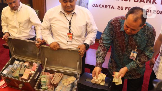 Direktur Departeman Pengelolaan Uang Bank Indonesia Yudi Harymukti (kanan) memusnahkan uang palsu di gedung Bank Indonesia, Jakarta, Rabu (26/2/2020). Bank Indonesia memusnahkan 50.087 lembar uang Rupiah palsu. (Liputan6.com/Angga Yuniar)