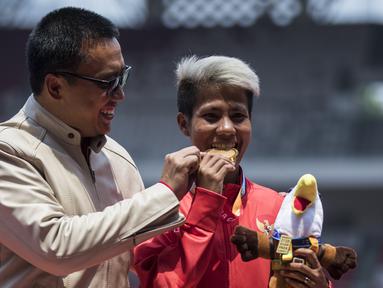 Atlet lompat jauh Indonesia, Rica Oktavia, foto bersama Menpora, Imam Nahrawi, usai meraih medali emas Asian Para Games 2018 di SUGBK, Jakarta, Senin (8/10/2018). (Bola.com/Vitalis Yogi Trisna)