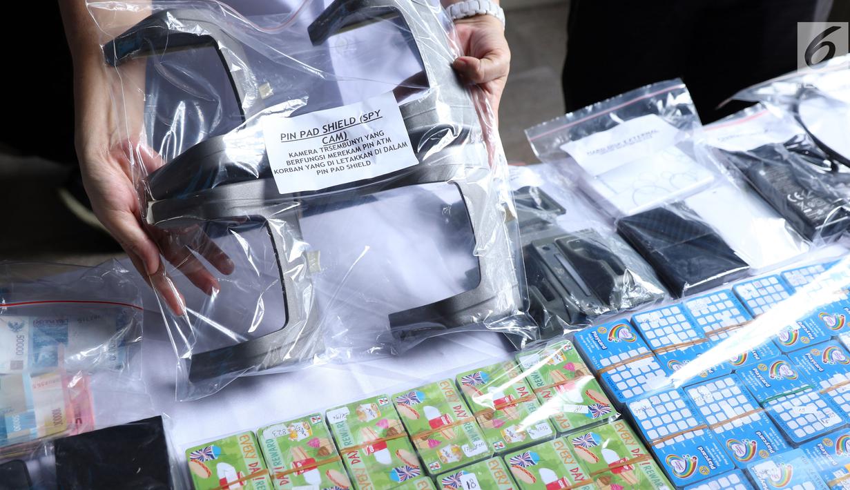 Petugas menunjukkan barang bukti pembobol uang dengan teknik skimming diperlihatkan petugas Resmob Polda Metro Jaya saat rilis di Jakarta, Sabtu (17/3). Sindikat ini membobol 64 bank pada sejumlah negara. (Liputan6.com/Helmi Fithriansyah)
