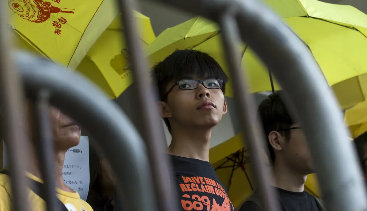 Joshua Wong saat menunggu di luar pengadilan, Hong Kong, Cina, Jumat (28/8/2015). Wong dituntut atas tuduhan memanjat pagar kompleks gedung pemerintah pada awal demonstrasi. (AFP PHOTO/Philippe Lopez)