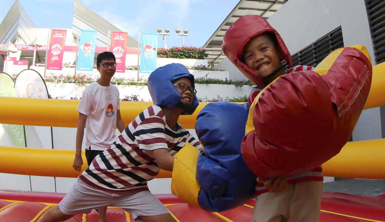 Anak-anak bermain Mega Boxing yang menjadi salah satu arena bermain di Karnaval SEA Games yang dihelat di kompleks Stadion Nasional Singapura. (Bola.com/Arief Bagus)