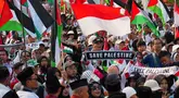 Para demonstran mengibarkan bendera Indonesia dan Palestina selama aksi unjuk rasa solidaritas untuk warga Palestina di Gaza, di Jakarta, Minggu 12 Oktober 2025. (AP Photo/Tatan Syuflana)