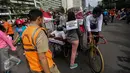 Pengunjung car free day (CFD) berkeliling memunguti sampah sampah di kawasan Bundaran HI, Jakarta, Minggu (29/1). Mereka juga mengenakan papan bertuliskan "Saya Berjanji Tidak Membuang Sampah Sembarangan" (Liputan6.com/Faizal Fanani)