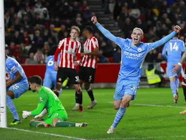 Pemain Manchester City Phil Foden melakukan selebrasi usai rekan setimnya Aymeric Laporte mencetak gol ke gawang Brentford yang kemudian dianulir oleh VAR pada pertandingan sepak bola Liga Inggris di Brentford Community Stadium, London, Inggris, 29 Desember 2021. (AP Photo/Ian Walton)