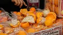 Seorang pria menunjukkan jeruk palsu berisi pil Captagon di Pelabuhan Beirut, Lebanon, 29 Desember 2021. Bea Cukai Lebanon menyita sembilan juta pil Captagon dalam jeruk palsu yang ditujukan ke salah satu negara Teluk. (ANWAR AMRO/AFP)