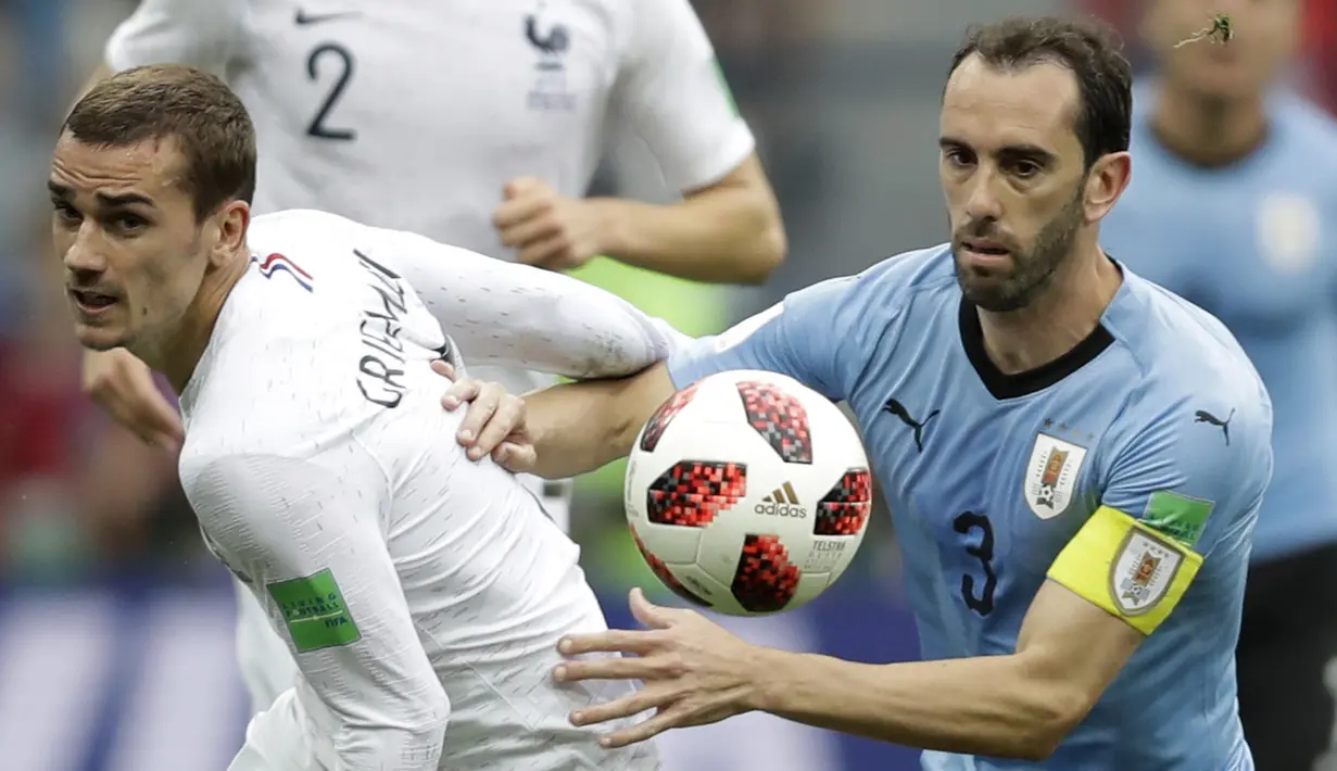Striker Prancis, Antoine Griezmann, berebut bola dengan bek Uruguay, Diego Godin, pada laga perempat final Piala Dunia di Stadion Nizhny Novgorod, Nizhny Novgorod, Jumat (6/7/2018). Prancis menang 2-0 atas Uruguay. (AP/Natacha Pisarenko)