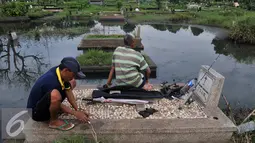 Warga mempersiapkan umpan saat memancing ikan di TPU Tanah Kusir, Jakarta Selatan, Jumat (26/8). Warga memanfaatkan Banjir yang merendam makam di kawasan tanah kusir ini terjadi akibat luapan Sungai Pesanggrahan. (Liputan6.com/Johan Tallo)