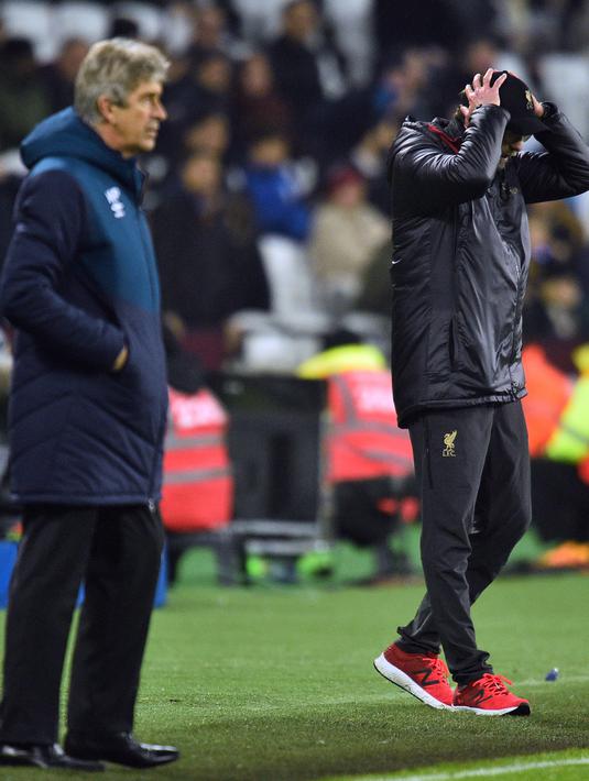 Pelatih Liverpool, Jurgen Klopp memegang kepalanya saat melihat pemainnya bertanding melawan West Ham United pada lanjutan Liga Inggris di The London Stadium (4/2). Hasil ini membuat posisi Liverpool ditempel ketat Manchester City. (AFP Photo/Glyn Kirk)