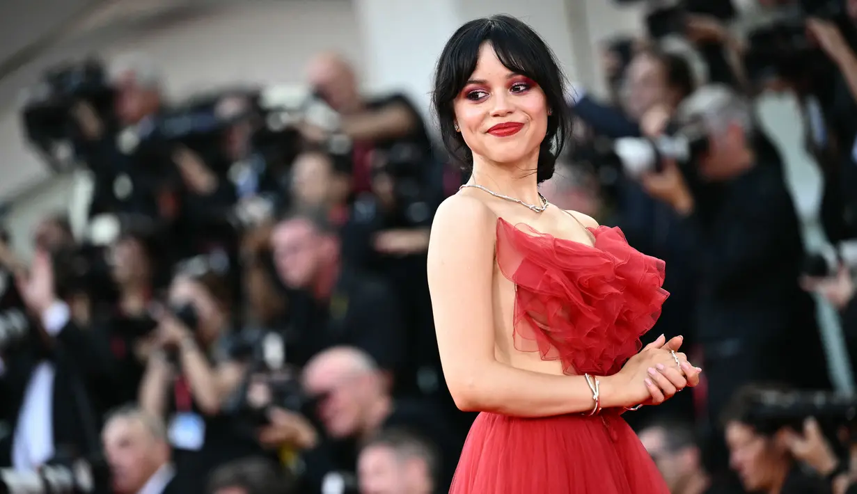 Aktris yang berperan sebagai Astrid Deetz dalam film ini, terlihat sangat sensasional dengan ansambel tipis yang menonjolkan bagian dada yang mengacak-acak, tali bahu yang tipis, dan desain backless. (Marco BERTORELLO / AFP)