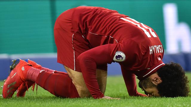 Gelandang Liverpool, Mohamed Salah, sujud merayakan gol yang dicetaknya ke gawang Brighton. (AFP/Glyn Kirk)