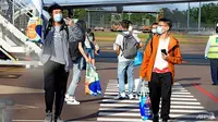 Mahasiswa asing turun dari penerbangan internasional di Bandara Darwin. Ini merupakan ketibaan pertama sejak penutupan perbatasan Australia pada Maret 2020. (Foto: AFP / JULES)