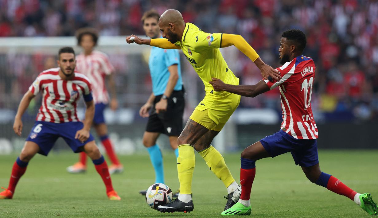 Gelandang Villarreal, Etienne Capoue (tengah) menguasai bola dibayangi gelandang Atletico Madrid, Thomas Lemar dalam laga Liga Spanyol 2022/2023 di Wanda Metropolitano Stadium, Madrid (21/8/2022). Pemain asal Prancis berusia 34 tahun ini tercatat pernah membela Tottenham Hotspur selama 2 musim pada 2013/2014 dan 2014/2015. Sejak musim 2020/2021 ia hijrah ke La Liga Spanyol untuk bergabung dengan Villarreal setelah sempat membela Watford selama 5,5 musim. (AFP/Thomas Coex)