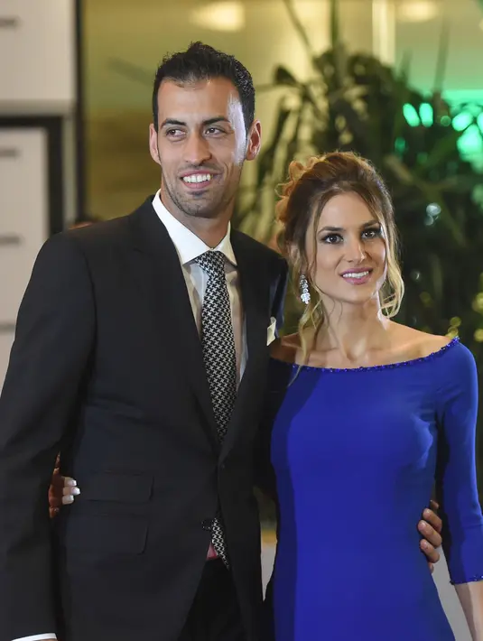 Pemain Barcelona, Sergio Busquets dan istrinya saat menghadiri pernikahan Lionel Messi di Rosario, Argentina (30/6). Acara ini dihadiri banyak pesepak bola dan selebriti terkenal dunia. (AFP Photo/Eitan Abramovich)