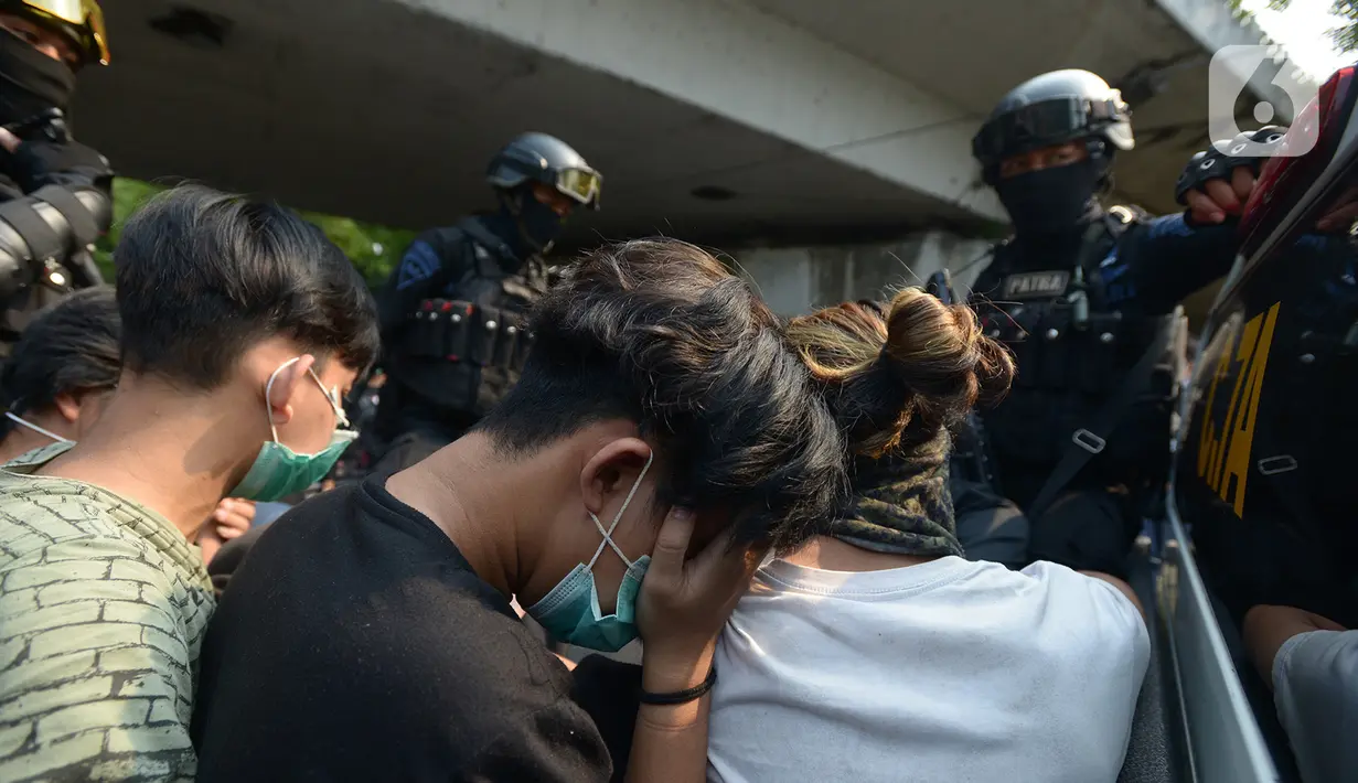 Polisi membawa pelajar yang terjaring razia saat berkumpul di sekitar Gedung DPR/MPR, Jalan Gatot Subroto, Jakarta, Rabu (7/10/2020). Sejumlah akses jalan menuju lokasi dijaga menyusul adanya aksi demonstrasi kelompok buruh yang menolak UU Omnibus Law Cipta Kerja. (merdeka.com/Imam Buhori)