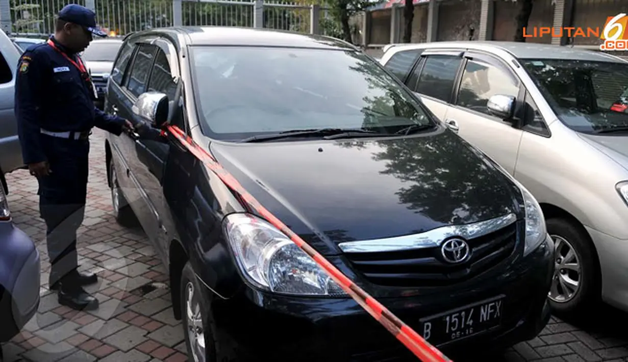 Sebuah Kijang Inova hitam tak luput dari aksi KPK yang terus menyelidiki keberadaan harta Wawan (Liputan6.com/Johan Tallo)