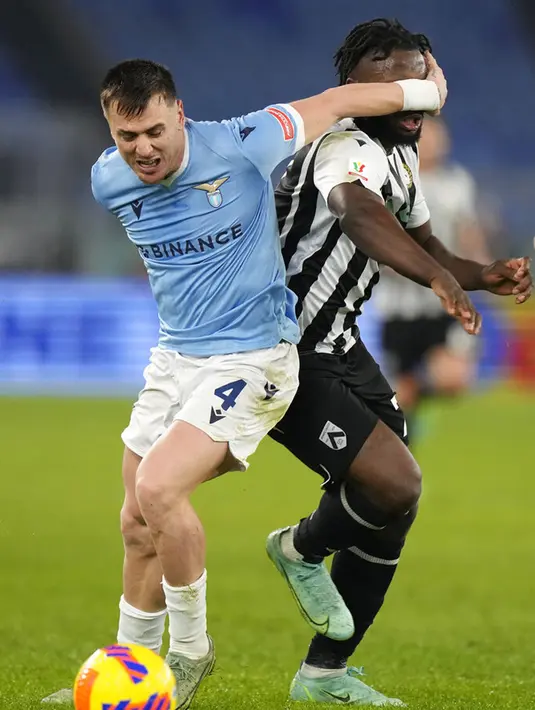 Pemain Lazio Patric (kiri) melanggar pemain Udinese Isaac Success pada pertandingan sepak bola Coppa Italia di Olympic Stadium, Roma, Italia, 18 Januari 2021. Lazio menang dengan skor 1-0. (AP Photo/Andrew Medichini)