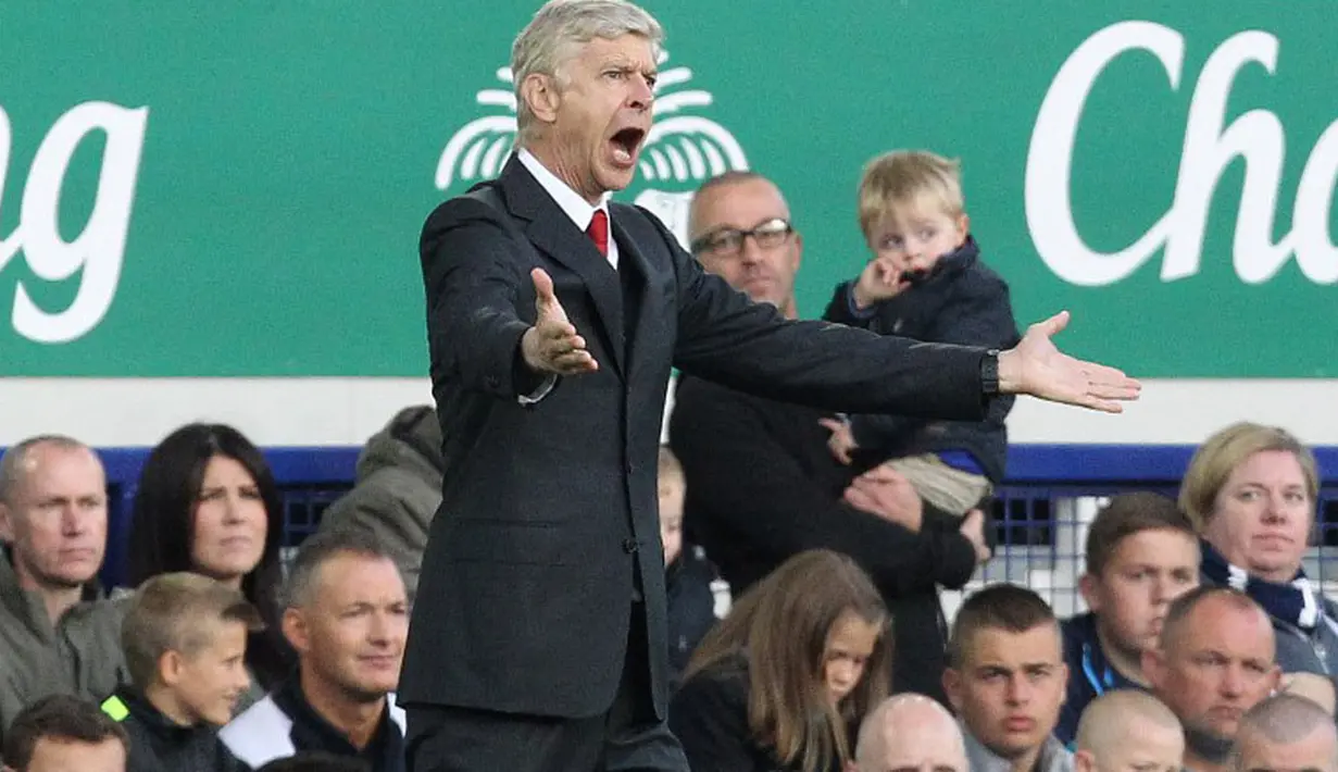 Pelatih Arsenal, Arsene Wenger, memberikan instruksi kepada timnya saat berlaga kontra Everton dalam laga lanjutan Liga Primer Inggris di Stadion Goodison Park, (24/8/2014). (AFP PHOTO/Lindsey Parnaby)