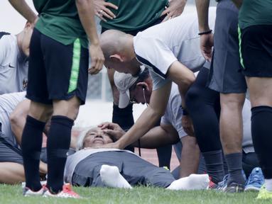 Dokter Timnas Indonesia, Syarif Alwi, memeriksa Danurwindo, yang pingsan usai memantau latihan di Stadion Wibawa Mukti, Jawa Barat, Sabtu (03/11/2018). Danurwindo ambruk ketika tim dan ofisial melakukan sesi foto bersama. (Bola.com/M Iqbal Ichsan)