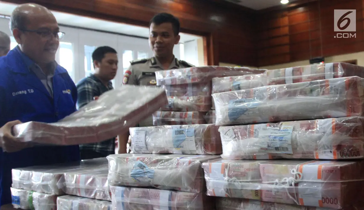 Pegawai menata uang ganti rugi korupsi BLBI dengan terpidana Samadikun Hartono di Gedung Bank Mandiri, Jakarta, Kamis (17/5). Sebelumnya, Samadikun sudah mengembalikan uang pengganti sebesar Rp 82 miliar. (Liputan6.com/Angga Yuniar)