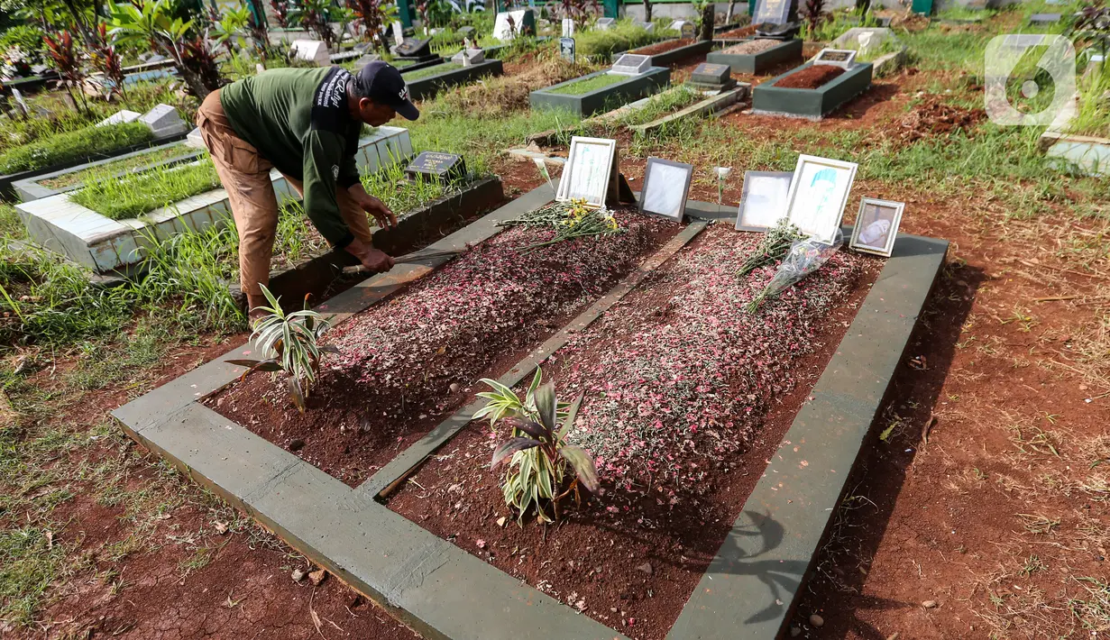 Sardi, pengurus makam membersihkan makam Vanessa Angel dan Bibi Ardiansyah di TPU Taman Makam Islam Malaka Blok D, Pesanggrahan, Jakarta, Senin (7/02/2022). Hingga kini, pengurus makam belum menerima surat izin dari pihak Doddy Sudrajat untuk memindahkan makam Vanessa. (Liputan6.com/Fery Pradolo)